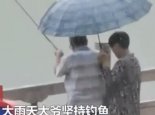 暴雨中大妈撑伞陪大爷钓鱼 网友：真让人羡慕